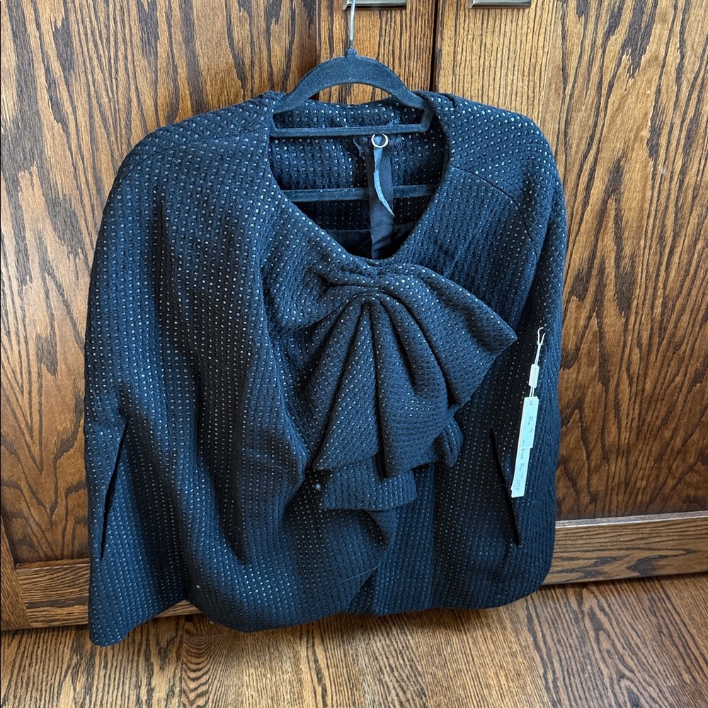 Poleci Cape With A Large Bow And A Dotted Texture.